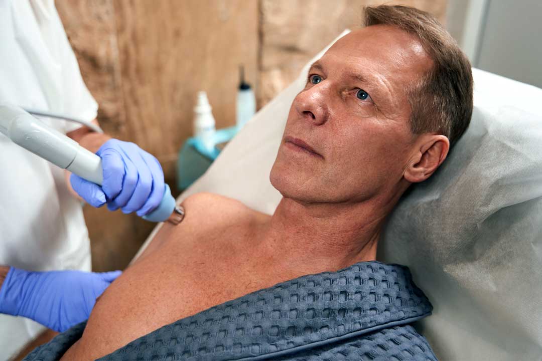 Man receiving focused shockwave therapy on his shoulder